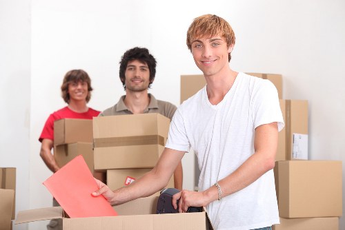Removalists handling furniture in a Rotherhithe flat with narrow access